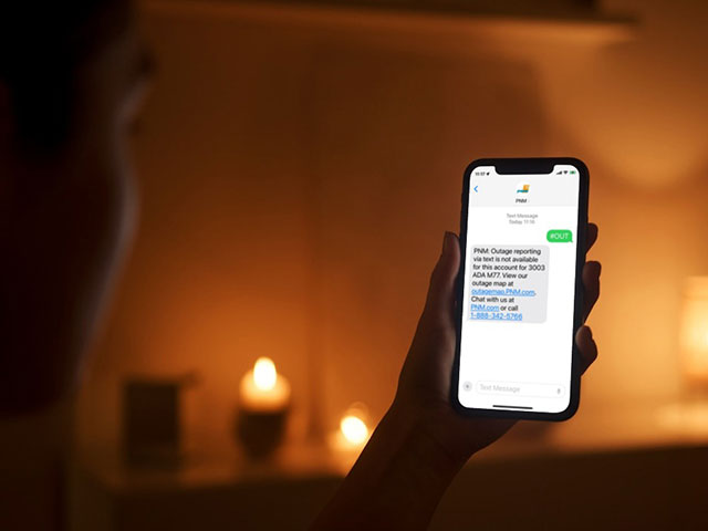 Woman in a candlelit room looking at her phone Woman in a candlelit room looking at her phone